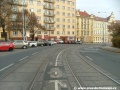 Táborská ulice klesá a stáčí se vpravo, stejně tak i tramvajová trať tvořená velkoplošnými panely BKV.