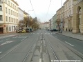 Koleje tramvajové tratě překračují křižovatku se Sezimovou ulicí po levé straně.
