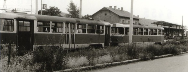 Vyřazené vozy T3 ev.č.6455 a ev.č.6364 na spojovací koleji mezi tramvajovou tratí a železnicí, v popředí je stále ještě funkční křížení železniční vlečky s tramvajovou tratí. | 21.6.1991