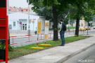 Zmatený cestující hledá v infotabulích zastávku bus. Nenajde, za chvíli se bude tázat fotografa na cestu.
