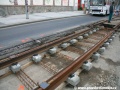 Směrově urovnaný kolejový rošt čeká na vyzvednutí do správné nivelety. V pozadí je ke spatření bus náhradní dopravy X-25. | 2.5.2011