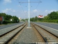 K protisměrným zastávkám Malešická továrna trať pokračuje ve středu Černokostelecké ulice otevřeným svrškem v táhlém levém oblouku.