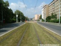 Zatravněný přímý úsek tramvajové tratě na zvýšeném tělese ve středu Černokostelecké ulice spěje k zastávkám Zborov, Strašnické divadlo.