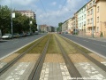 Přímý úsek zatravněné tramvajové tratě ve středu Černokostelecké ulice.