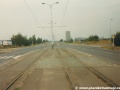 Původní podoba tramvajové tratě v úseku smyčka Ústřední dílny DP - smyčka Černokostelecká s rozpadajícím se asfaltovým zákrytem a zastávkami bez nástupních ostrůvků. | 20.8.1995