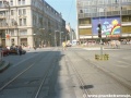 Pohled do jednokolejky od zastávky Václavské náměstí, přes náměstí samotné. Vpravo na sloupu zdvojená tramvajová signalizace s doplňkovým návěstidlem.