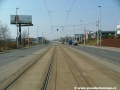 Tramvajová trať v přímém úseku tvořeném velkoplošnými panely BKV pokračuje na zvýšeném tělese ve středu Kolbenovy ulice.