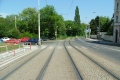 Tramvajová trať, jejíž kryt tvoří malá žulová dlažba, klesá od Pohořelce.
