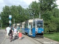 Typická polská tramvaj - čtyřnápravový vůz typu Konstal 105Na se čtyřmi dveřmi. Zde velmi zachovalý vůz č. 394 vede soupravu na lince 14 v zastávce Rondo Mogilskie. Parčík v pozadí se nachází uvnitř velké okružní křižovatky | 10.8.2004