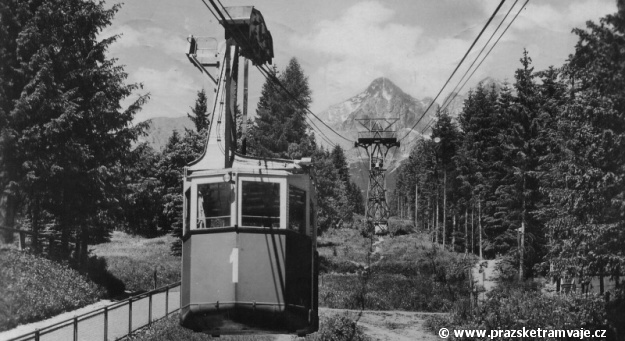 Na pohlednici odeslané v roce 1951 kabinka číslo 1 visuté lanové dráhy Tatranská Lomnice - Skalnaté Pleso zahajuje stoupání z údolní stanice Tatranská Lomnice