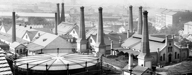 První žižkovská obecní plynárna okolo roku 1918 v pohledu zhruba k hlavnímu nádraží. Činžovní domy v pravé části snímku ohraničují do dnešních dnů Seifertovu ulici.