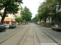 Tramvajová trať tvořená velkoplošnými panely BKV pokračuje ve středu vozovky ulice Komunardů v přímém úseku