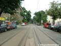 Tramvajová trať tvořená velkoplošnými panely BKV pokračuje ve středu vozovky ulice Komunardů v přímém úseku