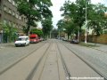 Tramvajová trať tvořená velkoplošnými panely BKV pokračuje ve středu vozovky ulice Komunardů v přímém úseku