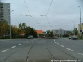 Tramvajová trať tvořená žlábkovou kolejnicí NT1 se stáčí v prostoru přejezdu pro automobily na křižovatce s Bazovského ulicí