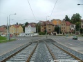 Tramvajová trať klesá ke světelně řízené křižovatce s Plzeňskou ulicí, z důvodu menšího poloměru oblouku opět přechází do žlábkových kolejnic