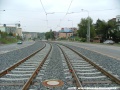 Tramvajová trať tvořená kolejnicemi S49 pokračuje v táhlém levém oblouku v otevřeném svršku k zastávce Hlušičkova