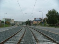 Tramvajová trať tvořená kolejnicemi S49 pokračuje v táhlém levém oblouku v otevřeném svršku k zastávce Hlušičkova