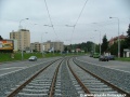 Klesání tramvajové tratě tvořené kolejnicemi S49 v táhlém pravém oblouku ve středu Plzeňské ulice