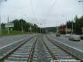 Klesání tramvajové tratě tvořené kolejnicemi S49 v táhlém pravém oblouku ve středu Plzeňské ulice