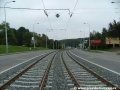 Klesání tramvajové tratě tvořené kolejnicemi S49 v táhlém pravém oblouku ve středu Plzeňské ulice