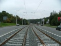 Klesání tramvajové tratě tvořené kolejnicemi S49 v táhlém pravém oblouku ve středu Plzeňské ulice