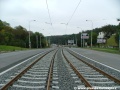 Klesání tramvajové tratě tvořené kolejnicemi S49 v táhlém pravém oblouku ve středu Plzeňské ulice