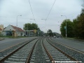 Tramvajová trať v otevřeném svršku tvořeném kolejnicemi S49 v táhlém pravém oblouku míjí kapličku, u níž do roku 1974 končily dvounápravové obousměrné vozy linky 9