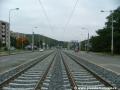 Tramvajová trať klesá v otevřeném svršku od zastávky Poštovka ve středu Plzeňské ulice