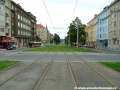 Přejezd tramvajový kolejí na úrovni Velflíkovy ulice, za ním je zazeleněný prostor opuštěné zastávky Lotyšská do centra.