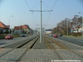 V přímém úseku ve středu Poděbradské ulice tramvajová trať zřízená bezžlábkovými kolejnicemi míří k zastávkám Kbelská.