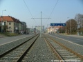 V přímém úseku ve středu Poděbradské ulice tramvajová trať zřízená bezžlábkovými kolejnicemi míří k zastávkám Kbelská.