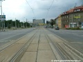 Tramvajová trať překračuje prostor křižovatky s Kbelskou ulicí, vpravo kdysi odbočovala na tramvajovou trať vedenou Kbelskou ulicí.