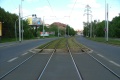 Po opouštění asfaltového zákrytu následuje krátký úsek otevřeného svršku a koleje se stáčí zatravněným táhlým pravým obloukem k zastávkám Radošovická.