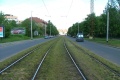 Táhlý zatravněný pravý oblouk tramvajové tratě ve středu Průběžné ulice míří k zastávkám Radošovická.