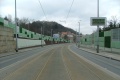 Tramvajová trať pokračuje táhlým pravým obloukem v klesání na zvýšeném tělese ve středu Radlické ulice.