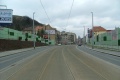 Tramvajová trať pokračuje táhlým pravým obloukem v klesání na zvýšeném tělese ve středu Radlické ulice.
