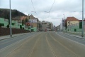 Tramvajová trať pokračuje táhlým pravým obloukem v klesání na zvýšeném tělese ve středu Radlické ulice.