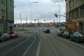 Tramvajová trať se ve středu Radlické ulice přibližuje ke světelně řízené křižovatce v níž ostrým levým obloukem odbočí do severní části Radlické ulice, kde jsou v prostoru obytné zóny zřízeny zastávky Křížová.