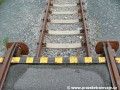 Detailní pohled na ukončení tramvajové koleje a začátek koleje železniční.