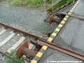 Detailní pohled na ukončení tramvajové koleje, železniční nárazníky a hák k uchycení šroubovnice železničního vozu na čele rampy předávací koleje.