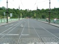 Tramvajová trať vstupuje na Čechův most, povrch vozovky zde tvoří asfaltový koberec.