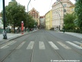 Tramvajová trať se na Smetanově nábřeží napřimuje, na levém chodníku vidíme zastávku Karlovy lázně.