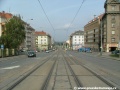 Tramvajová trať na zvýšeném tělese tvořeném velkoplošnými panely BKV klesá středem Svatovítské ulice.