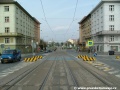 Tramvajová trať na zvýšeném tělese tvořeném velkoplošnými panely BKV klesá středem Svatovítské ulice.