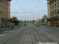 Tramvajová trať na zvýšeném tělese tvořeném velkoplošnými panely BKV klesá středem Svatovítské ulice.