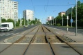 Za křižovatkou s Práčskou následuje přechod pro chodce a tramvajová trať stoupá v přímém úseku.