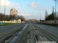 Tramvajová trať klesá ve středu Vinohradské ulice k zastávce Krematorium Strašnice a míjí křižovatku s Počernickou ulicí v levé části fotografie