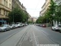 Tramvajová trať tvořená velkoplošnými panely BKV klesá středem Vinohradské ulice.