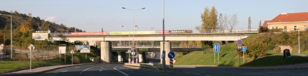 Celkový pohled na železobetonový most přes přeloženou a rozšířenou ulici v Podbabě pocházející z roku 1996, v pravé části snímku je v náspu železniční vlečky vidět cihlový tunýlek, následovaný podchodem pod vlastní železniční tratí na Kralupy. Než došlo k megalomanskému rozšíření Podbabské ulice, byl tento tunýlek jedinou spojnicí Dejvic s Papírenskou ulicí | 23.10.2010